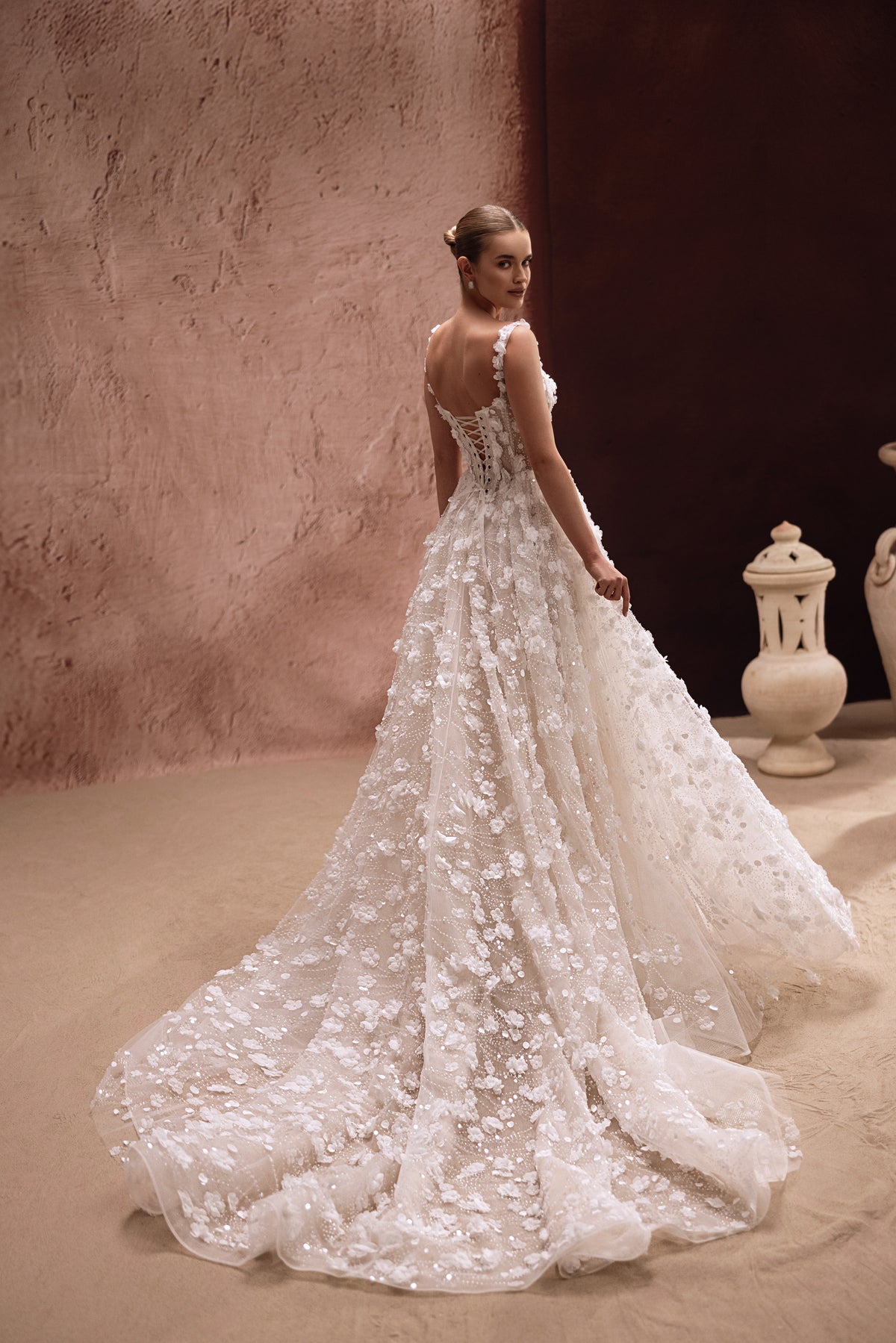 The Cintra wedding gown with a voluminous skirt and 3D floral embellishments creates a glamorous, royal-inspired bridal look.