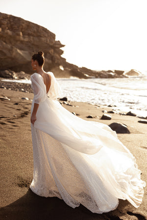 Brautkleid Davina von hinten am Strand, offener Rücken und lange Tüllschleppe