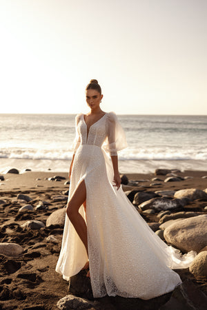 Brautkleid Davina, ganze Silhouette am Meer bei Sonnenuntergang mit Schlitz im Rock