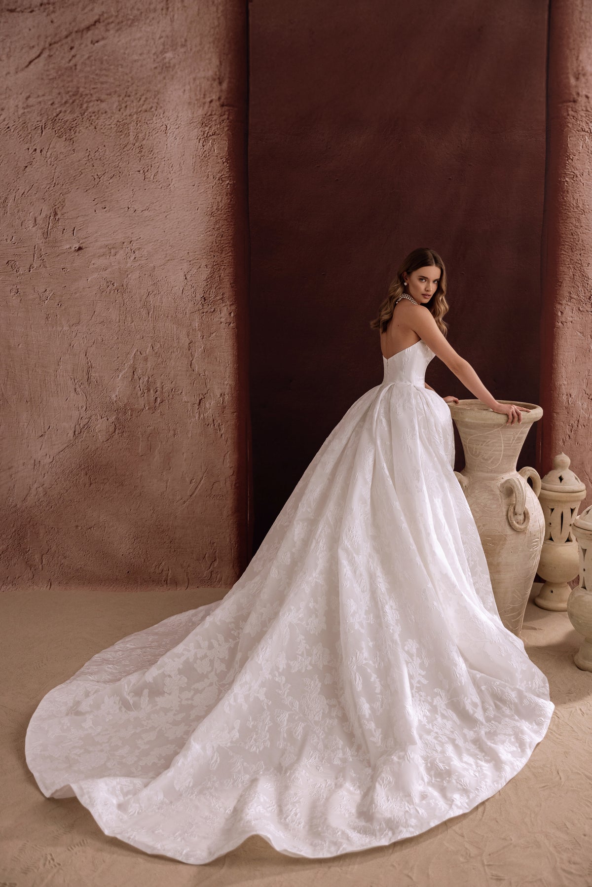 Brautkleid Hebe von hinten, die Jacquardschleppe liegt weit ausgebreitet am Boden