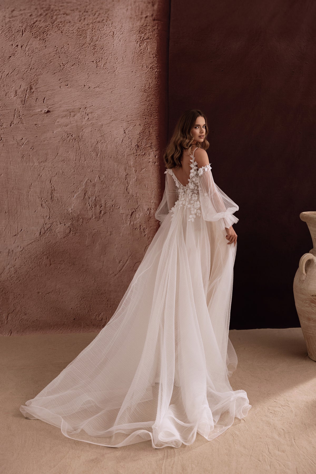 Brautkleid Lilibeth von der Seite mit weichem Tüllrock und Schleppe zwischen Amphoren