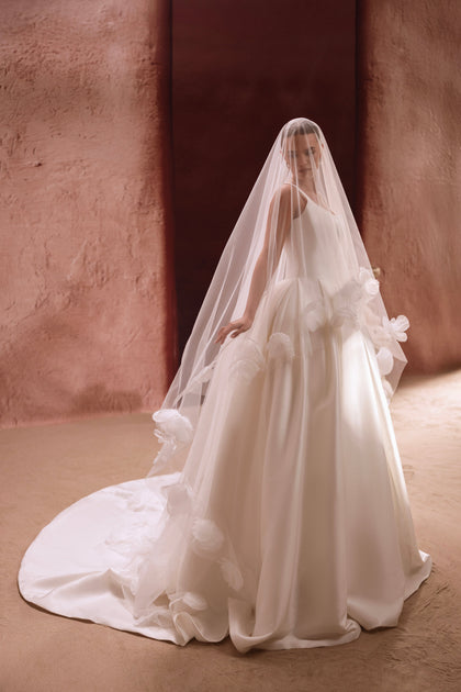 Das Hochzeitskleid Nicolette mit langem Schleier und Blumenapplikationen sorgt für einen romantischen, anmutigen Look.