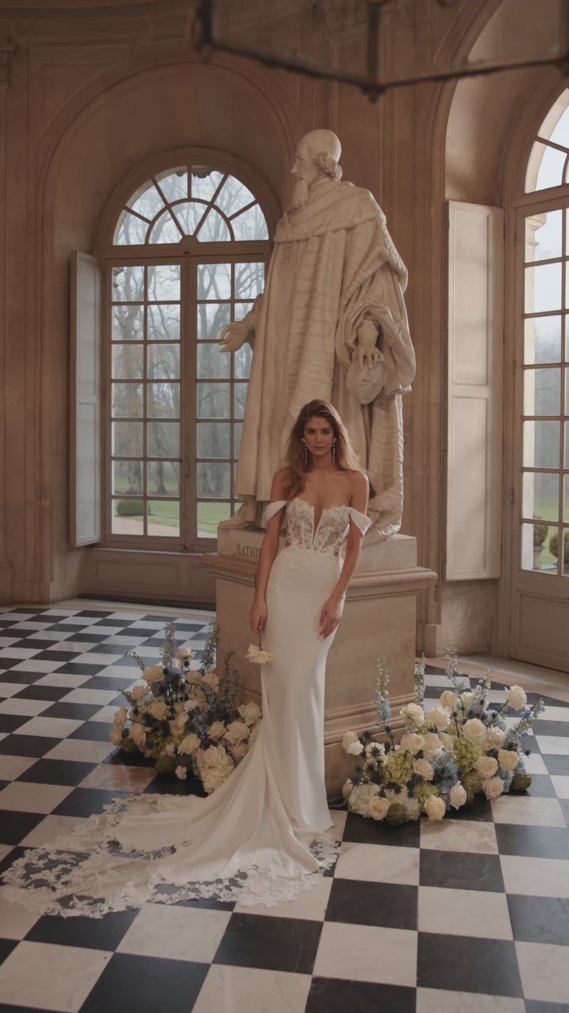 Video of the Matilde wedding dress in motion – mermaid silhouette with an off-the-shoulder neckline and lace-traced fitted silhouette.