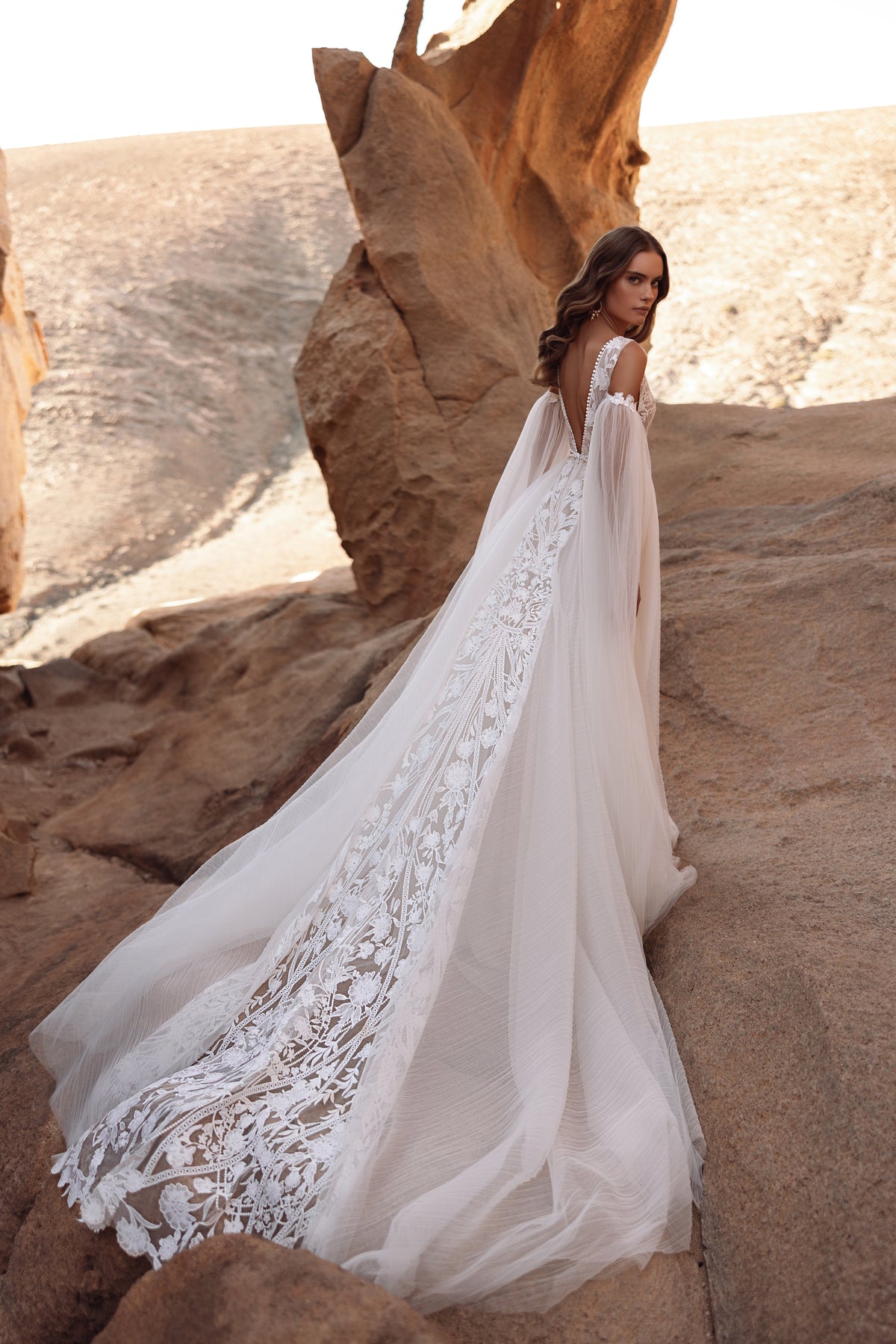 Brautkleid Salome von hinten, lange Spitzenschleppe über den Wüstenfelsen