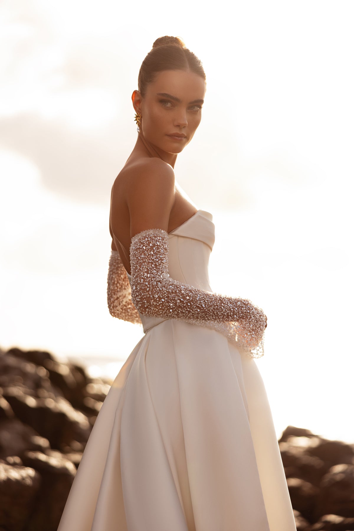 The Sarabi wedding dress with an open back and sweeping train blends timeless elegance with modern minimalism.