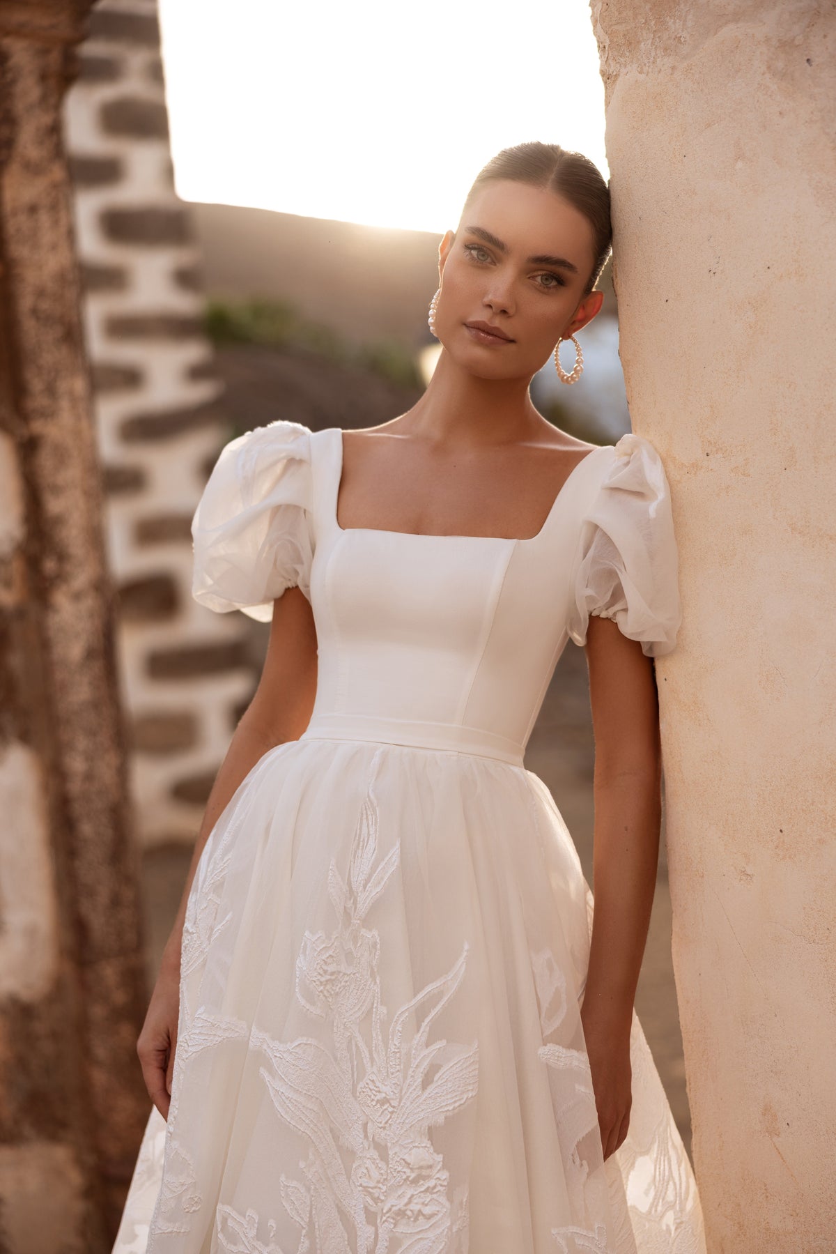 Brautkleid Vanilla an der Steinmauer, Puffärmel und viereckiger Ausschnitt